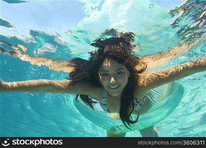 Young woman swimming in pool, underwater view