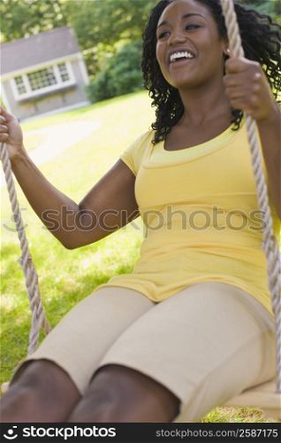 Young woman swinging on a swing