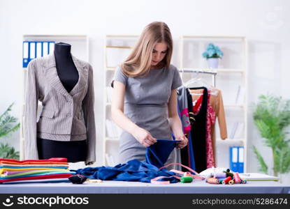 Young woman tailor working in workshop on new dress