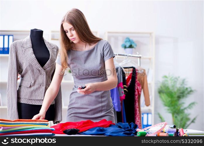 Young woman tailor working in workshop on new dress