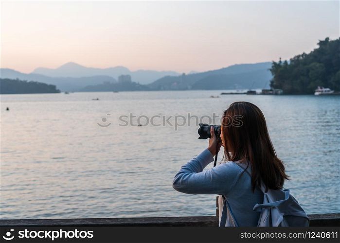 Young woman take a photo at the view in front of her.