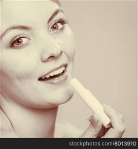 Young woman take balm on lips.. Female put on skin moisturizing balsam. Keep smoothing lipcare