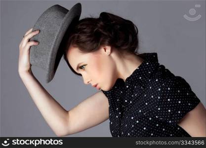 Young woman take off her hat and bow, side view.