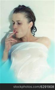 young woman taking a bath with a cigarette