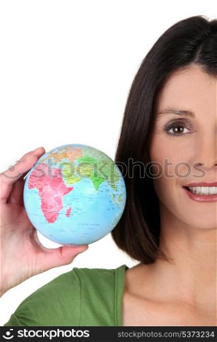 young woman taking a little globe in her hand