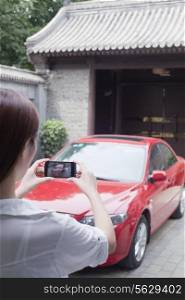 Young Woman Taking a Picture of Her Car