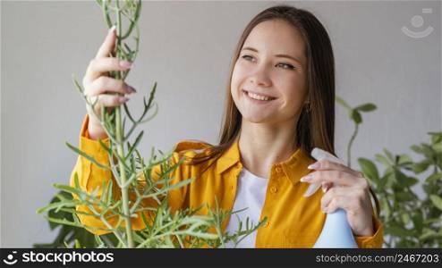 young woman taking care her plants home