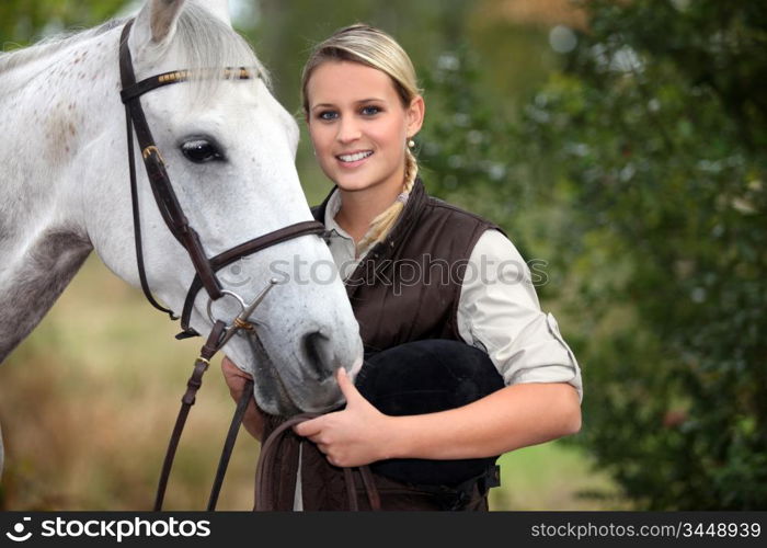 young woman taking care of her horse