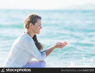 Young woman taking handful of water