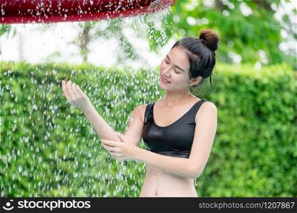Young woman taking shower at swimming pool in luxury resort hotel. Travel and summer lifestyle.