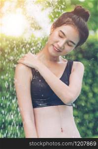 Young woman taking shower at swimming pool in luxury resort hotel. Travel and summer lifestyle.. Woman taking shower at swimming pool in resort.