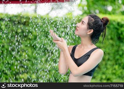 Young woman taking shower at swimming pool in luxury resort hotel. Travel and summer lifestyle.