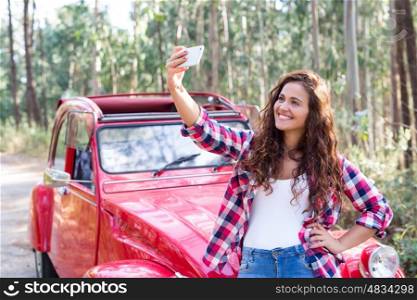 Young woman talking a selfie celebrating the start of a roadtrip