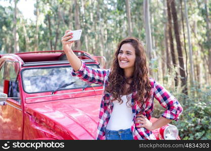 Young woman talking a selfie celebrating the start of a roadtrip