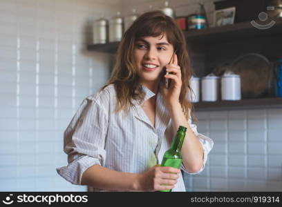 Young woman talking on a mobile phone at home.