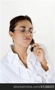 Young woman talking on a mobile phone with her eyes closed