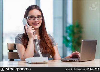 Young woman talking on phone in office