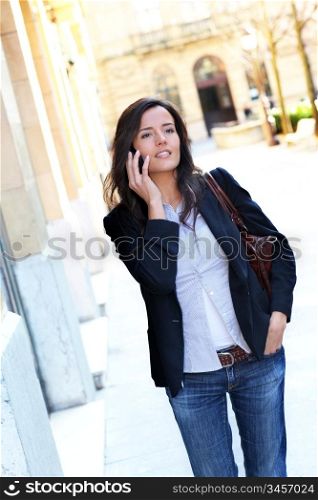 Young woman talking on the phone in the street