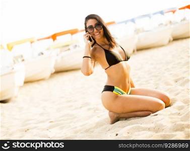 Young woman talking over the phone on the beach