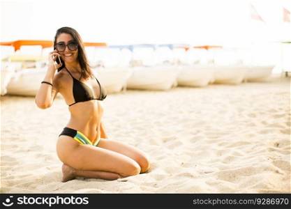 Young woman talking over the phone on the beach