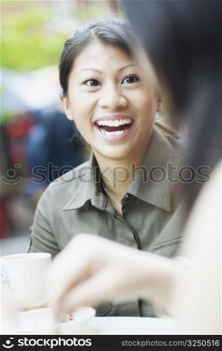 Young woman talking to another woman and laughing