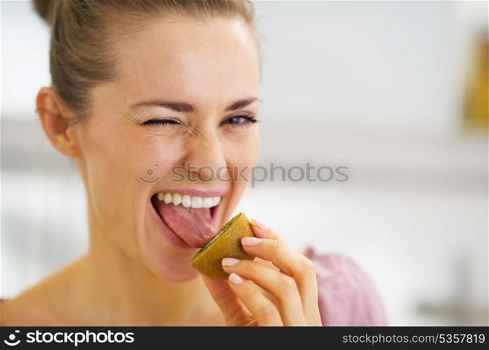 Young woman tasting kiwi