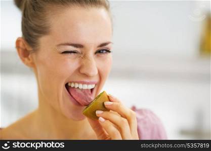 Young woman tasting kiwi