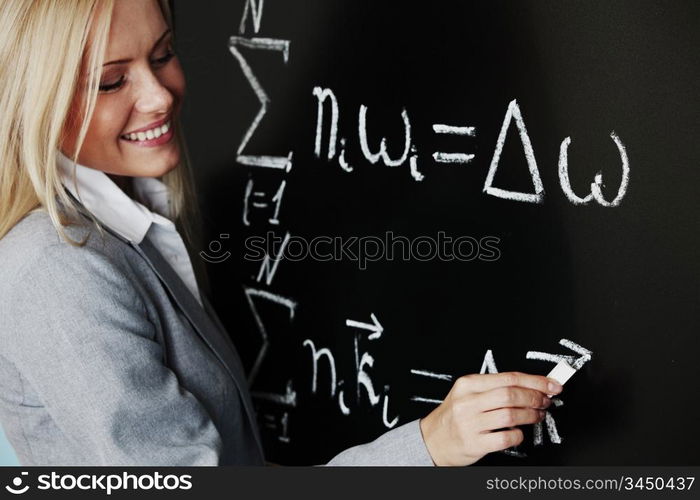 young woman teacher in front of a blackboard