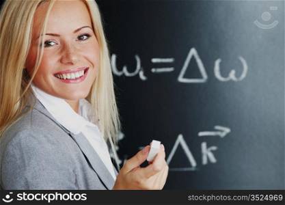 young woman teacher in front of a blackboard
