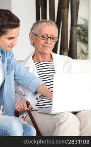 Young woman teaching her grandmother how to use the internet