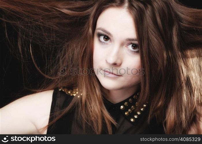 Young woman teen girl having fun pulling her long brown hair on black