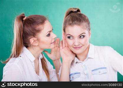 Young woman telling her friend some secrets, two women talking gossiping. Excited emotional girl whispering to human ear. Two teenagers shares secrets, gossip