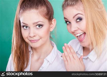 Young woman telling her friend some secrets, two women talking gossiping. Excited emotional girl whispering to human ear. Two teenagers shares secrets, gossip
