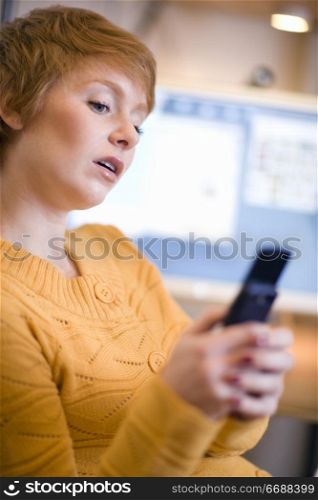 Young woman text messaging on cell phone
