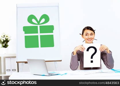 Young woman thinking about presents and sitting in office