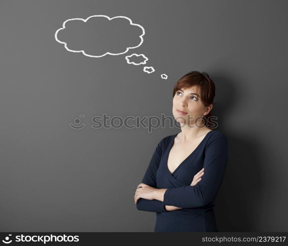 Young woman thinking with a thought a balloon drawn with chalk on the wall