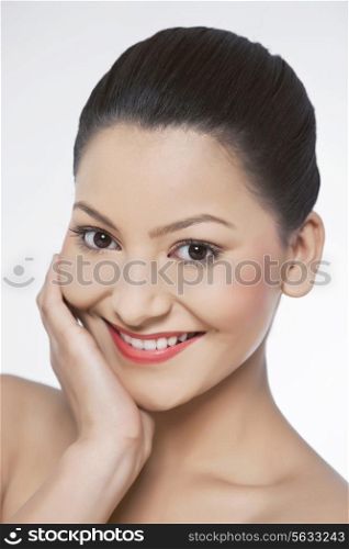 Young woman touching her face over white background