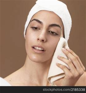 young woman touching her face with towel