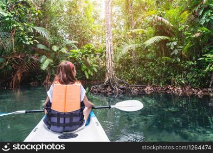 Young woman tourist paddling the kayak at klong root in Krabi, Thailand