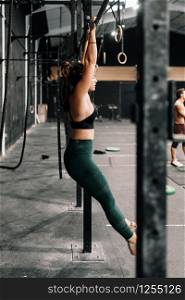 Young woman training on bar in a gym
