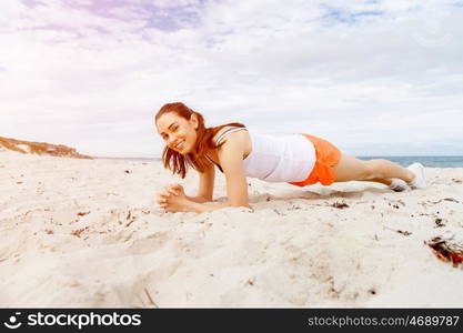 Young woman training on beach outside. Young woman training alone on beach outside