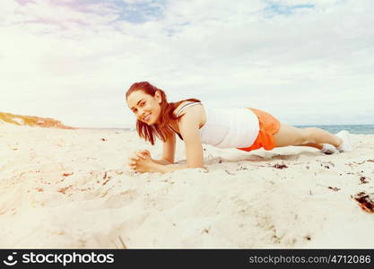 Young woman training on beach outside. Young woman training alone on beach outside