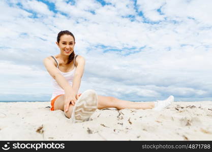 Young woman training on beach outside. Young woman training alone on beach outside