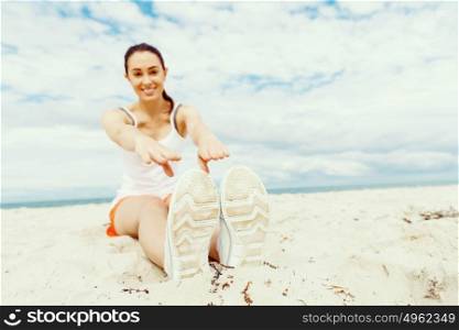 Young woman training on beach outside. Young woman training alone on beach outside