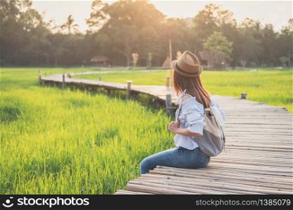 Young woman traveler looking at beautiful green paddy field