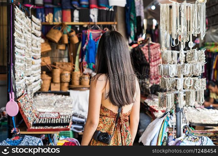 Young woman traveler looking for some souvenir at ubud market in bali. Young woman traveler at ubud market in bali