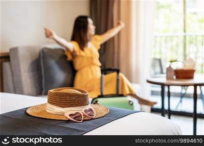 Young woman traveler sitting and relaxing in a hotel room while on summer vacation, Travel lifestyle concept