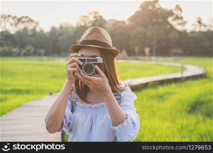 Young woman traveler taking a photo at beautiful green paddy field
