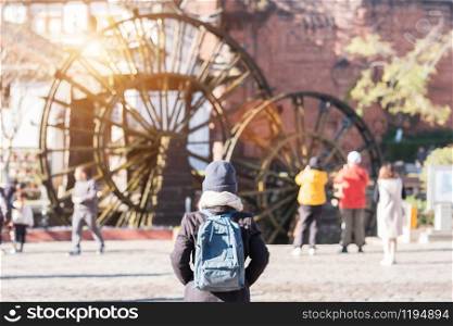 young woman traveler traveling at Giant Water Wheels in Lijiang Old Town, landmark and popular spot for tourists attractions in Lijiang, Yunnan, China. Asia travel concept