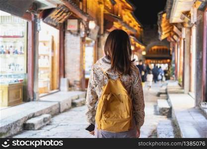 Young woman traveler walking at lijiang old town night market